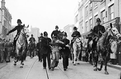 Eddie Worth, An anti-fascist demonstrator is taken away under arrest after a mounted baton charge during the Battle of Cable Street, London, 4 October 1936 © Alamy